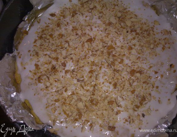 На полуготовый корж выкладываем половину будущей мернги и посыпаем половиной миндаля. Допекаем еще 15 мин