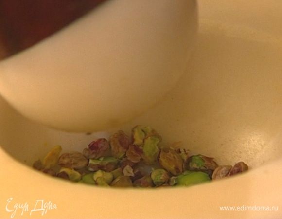 Оставшиеся фисташки измельчить в ступке или с помощью скалки так, чтобы получились кусочки разного размера.