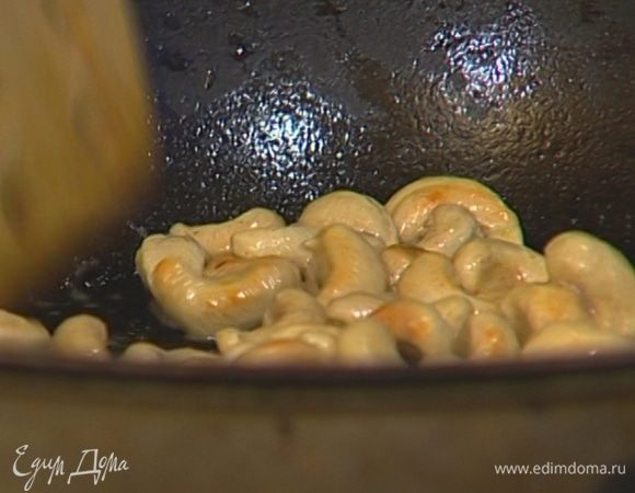В тяжелой глубокой сковороде разогреть сливочное масло и обжарить кешью. 