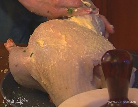 Оставшимся маслом смазать птицу и большой широкий лист бумаги для выпечки. 