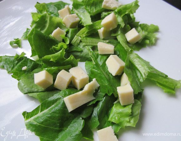 Сыр порезать кубиком и выложить на листья салата
