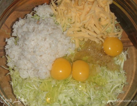 Отварить рис, и оставит под закрытой крышкой 3 мин. Лук обжарить на масле до золотистого цвета. Все это кладем в глубокую миску и добавляем кабачок, рис, пол стакана сыра и яйца. Все это перемешиваем и добавляем соль и перец. 