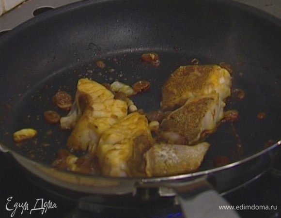 Изюм с шафраном и портвейном выложить в сковороду, влить 125 мл воды и довести до кипения. Затем добавить кусочки рыбы и потомить их по 1 минуте на каждой стороне.