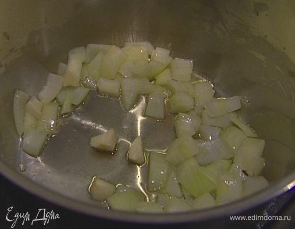 В высокой и тяжелой кастрюле разогреть оливковое масло, обжарить лук и чеснок до прозрачности. 