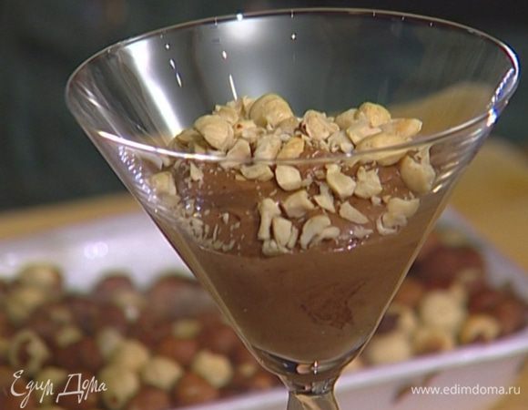В прозрачные бокалы выложить слой черного шоколада, присыпать измельченными орехами.
