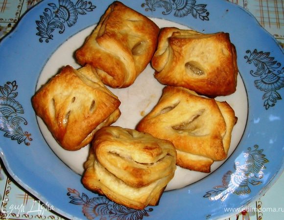 Раскатать слоёное тесто, вырезать квадраты 10Х10 см. Нижнюю половинку посыпать сахаром, прикрыть её второй половиной.
Теперь половину прямоугольничка посыпать сахаром и снова прижать соседней частью. Вдавить пальцем тесто, сделать прорези.
Смазать водой или подсолнечным маслом и выпекать в разогретой до 200 градусов духовке.