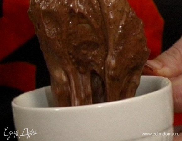 Большой ложкой выложить тесто в каждую смазанную маслом чашку или стакан, затем один шоколадный кубик из формочки для льда и сверху еще одну ложку теста.