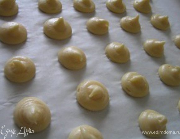 Заполнить заварным тестом кондитерский шприц с круглой насадкой и отсадить на выстеленный бумагой для выпечки противень 20 шариков одинакового размера.