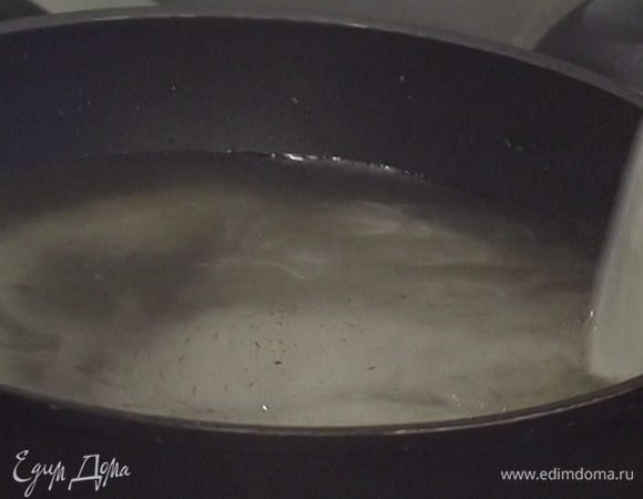 Влить в большую тяжелую сковороду 600 мл воды, всыпать ванильный сахар и поставить на огонь, чтобы сахар растворился.