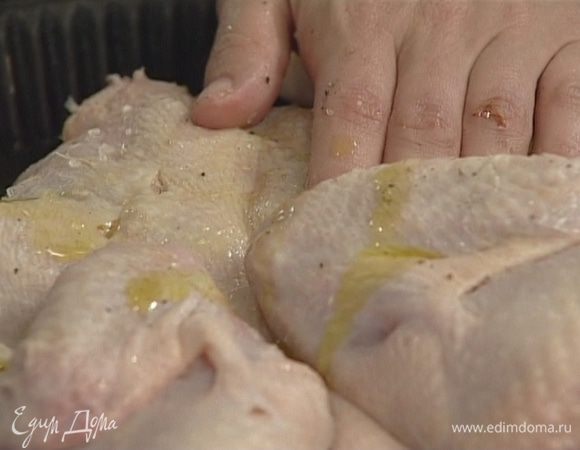 Курицу посолить, поперчить, сделать в некоторых местах небольшие надрезы, отделить кожу от мяса и поместить туда кусочки чеснока. Обмазать курицу оливковым маслом, уложить на противень, отправить в разогретую духовку и запекать, не накрывая, 40-45 минут.