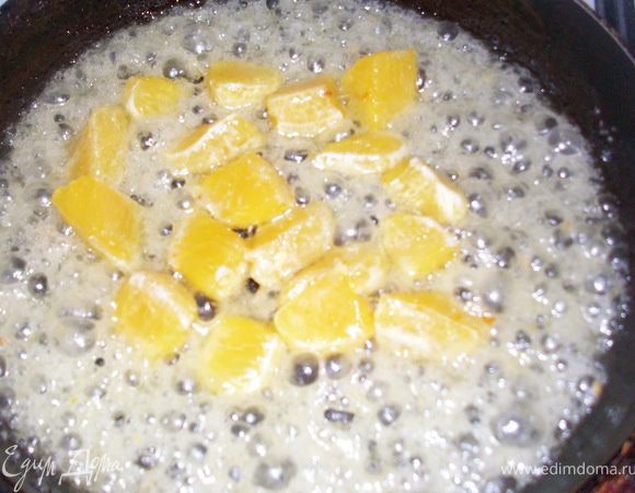 разогреваем сковородку, растапливаем масло, добавляем воду и сахар, доводим до кипения, выкладываем апельсины и яблоки, помешивая провариваем несколько минут