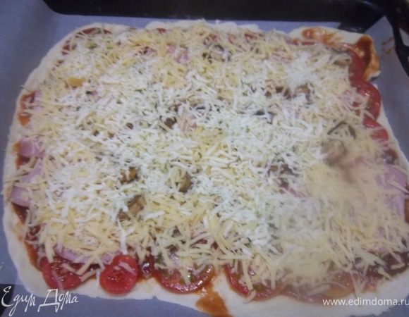 Сверху смазать тонким слоем томатной пасты, затем выложить грибы, ветчину и нарезанные кружочками помидоры. Посыпать натертым сыром.