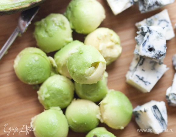 С авокадо снять кожуру, вынуть косточку, ложкой сформировать из мякоти небольшие шарики и уложить на салат.