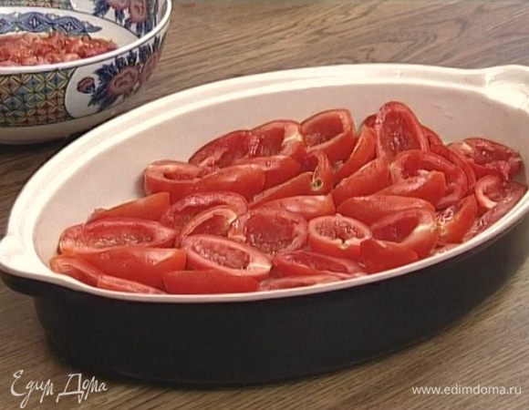 Уложить половинки помидоров в форму для запекания или в глубокий противень в один слой разрезанной стороной кверху.