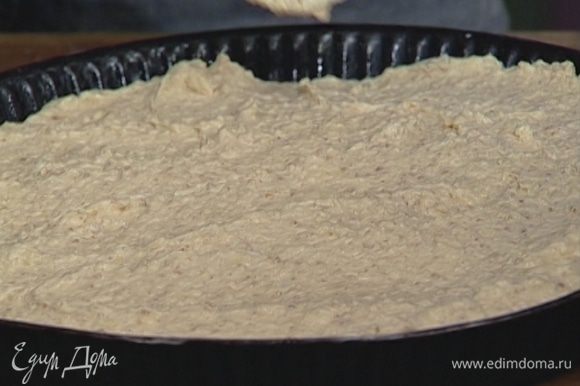 Круглую форму для выпечки смазать оставшимся сливочным маслом и выложить в нее тесто, равномерно распределяя его.