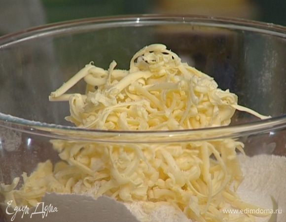 Приготовить тесто: в просеянную муку на крупной терке натереть 175 г предварительно охлажденного сливочного масла, добавить щепотку соли и перемешать до состояния крупной крошки. 