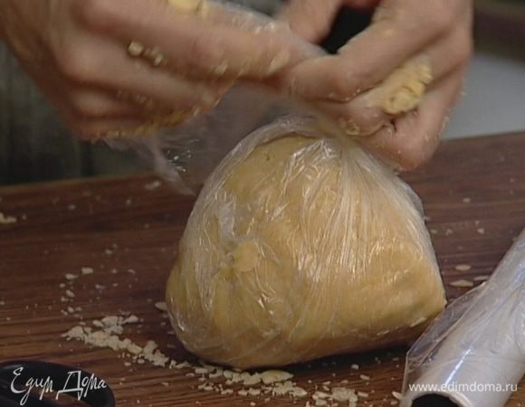 Добавить сахарную пудру и 3 желтка, замесить тесто, сформировать из него шар, завернуть в пленку и положить в холодильник на 40–60 минут.