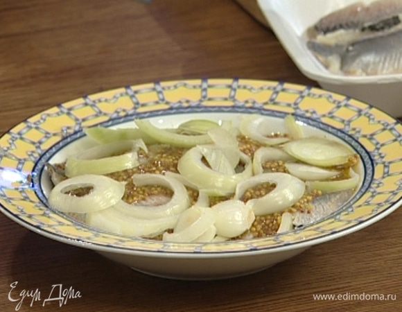 Равномерно выложить половину нарезанного лука на тарелку, сверху уложить всю селедку, намазать горчицей, полить уксусом и растительным маслом, накрыть оставшимся луком и поставить на некоторое время мариноваться.
