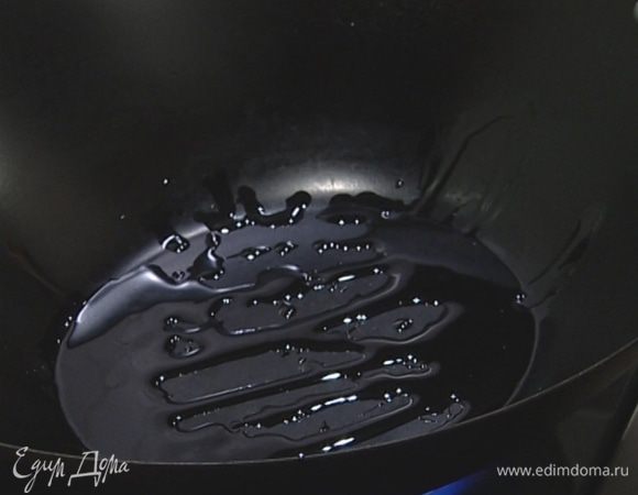 Разогреть вок, влить кунжутное масло.