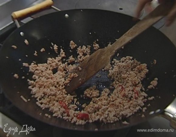 Выложить в вок свиной фарш и жарить 5—8 минут, постоянно помешивая.