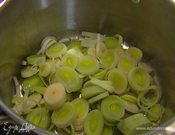 В большой кастрюле разогреть 2 ст. ложки овощного бульона, добавить лук-порей и чеснок. Прогревать 10 минут, непрерывно помешивая, пока лук не станет мягким.