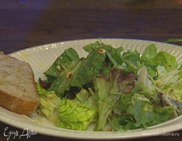 Заправить получившимся соусом листья салата, выложить их на тарелку, поперчить, присыпать кедровыми орехами.