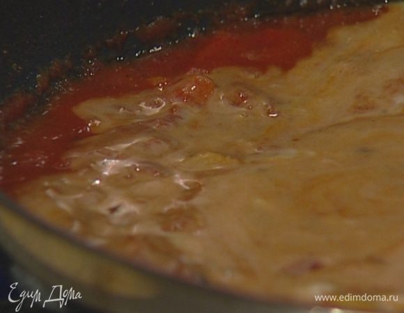 Помидоры нарезать дольками и добавить в сковороду, уложив их кожицей вниз. Слегка посолить, полить кокосовым молоком и томить на медленном огне 30 минут. 