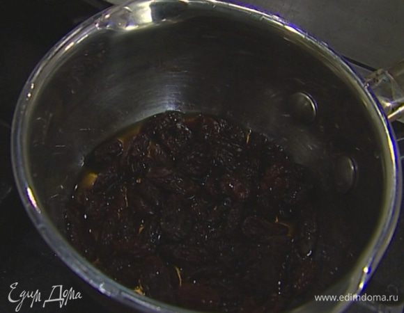Изюм выложить в небольшую кастрюлю, залить ромом и прогреть на небольшом огне.