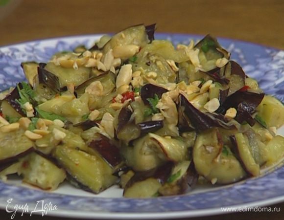 Баклажаны заправить, добавить половину орехов и перемешать. Подавать, присыпав оставшимися орехами.