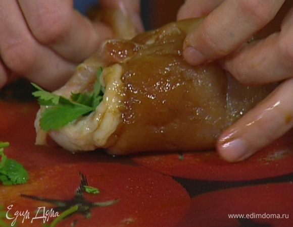 Выложить немного лука и кинзы на полоски курицы и свернуть их в рулетики. 