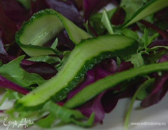 Выложить на блюдо салат, а сверху — полоски огурца. 