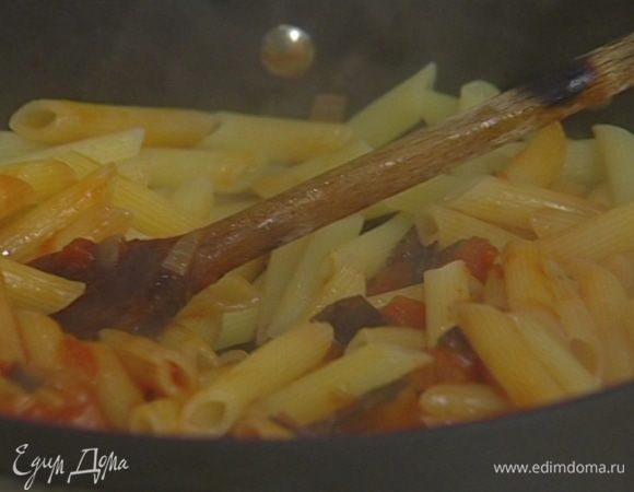 Выложить в сковороду к соусу макароны, фету, половину листьев базилика и все перемешать. Если получилось суховато, влить немного оставшейся после варки макарон воды и снова перемешать.