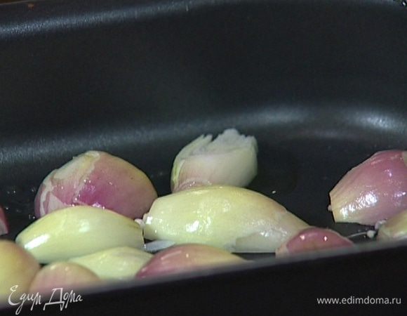 Лук почистить, разрезать пополам, уложить на дно противня, сбрызнуть растительным маслом, посолить и поперчить.