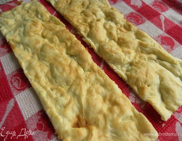 Коржи остудить и каждый разрезать на 2 равные части. Одну из полосок мелко накрошить ножом.