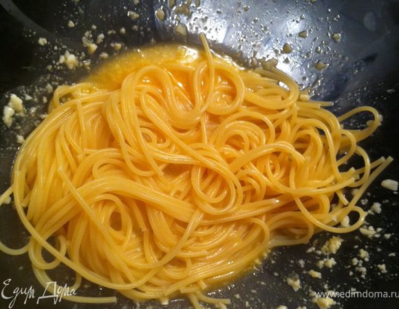 затем пасту при помощи щипцов перекладываем к яйцам и сыру и добавляем 1 ст. ложку воды в которой варилась паста