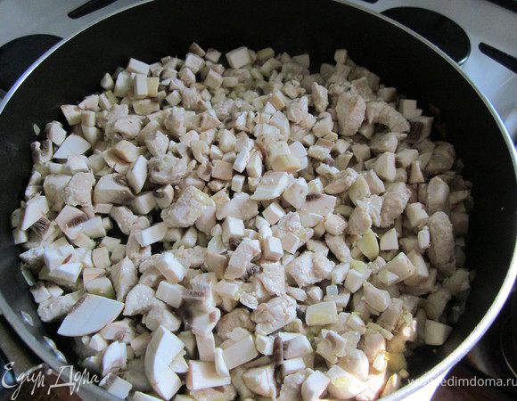 Грибы нарезать кубиком и добавить к курице. Готовить до выпаривания всей жидкости