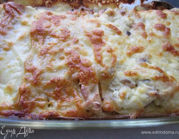 Всыпьте сыр и мешайте, пока он не расплавиться. Готовый соус вылить на каннелони и запекать их в духовке 30-40 минут до румяной корочки. Дайте ему немного постоять в форме и аккуратно порежьте, стараясь не повредить сами каннелони. Перед подачей можно слегка посыпать сыром и украсить зеленью. Приятного аппетита. 