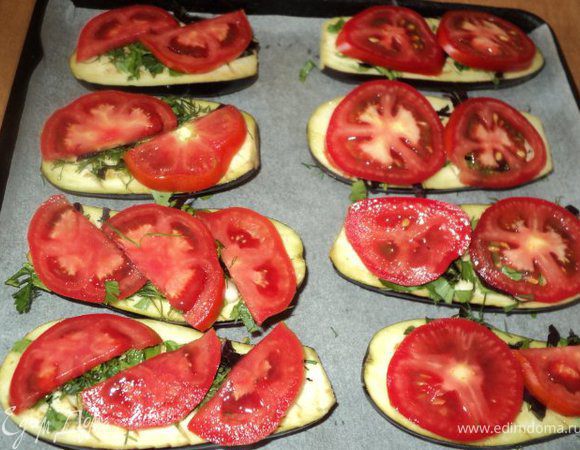 Сверху баклажаны посыпать зеленью, выложить пластинки помидора,