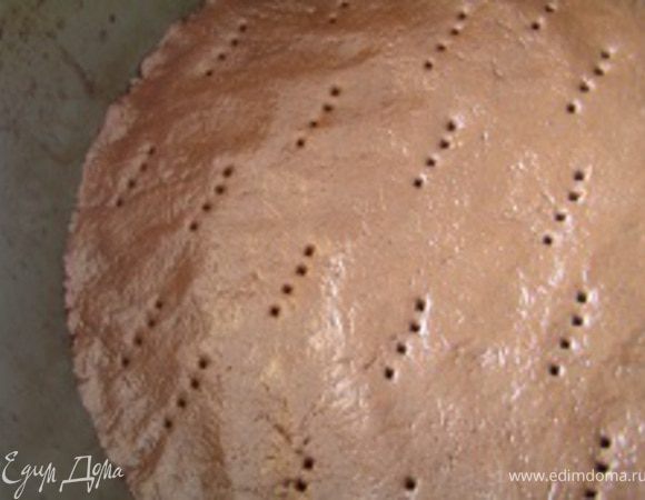 Тесто распределить руками в разъемной форме для выпечки. Проколоть в нескольких местах вилкой.