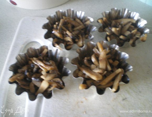 В каждую формочку положить немного грибов.