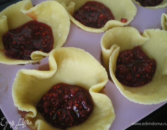 Тесто выложить в формы и наполнить чуть-чуть ягодным джемом.