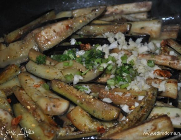 Посыпьте орегано, верните их все в сковороду, добавьте чили, чеснок и стебли базилика., 