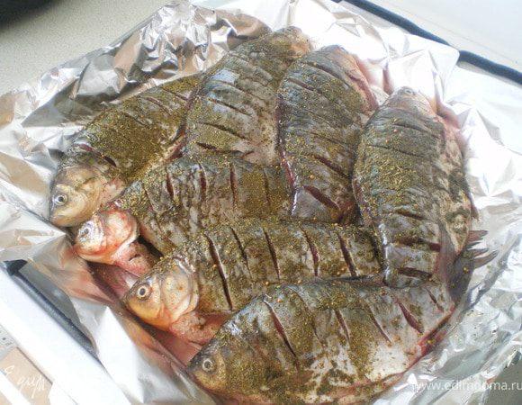 Рыбу почистить, выпотрошить, сделать надрезы. Сбрызнуть соком лимона. Посолить. Приправить специями. Запекать в духовке при 180 С в течение 40-60 минут.