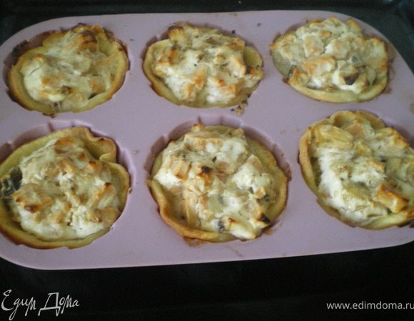 Приготовить начинку: яблоки и бананы нарезать кусочками. Добавить творог и перемешать. Тесто улодить в формочки и наполнить начинкой. На каждую корзиночку положить кусочек сливочного масла. И поставить запекаться в духовку на 35 минут.