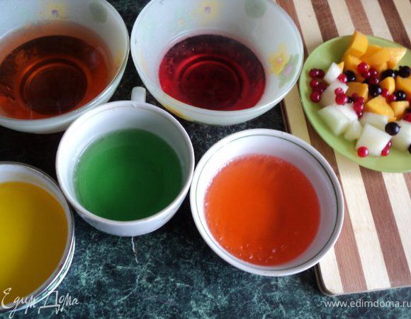 Растворить в разных емкостях по ½ пачки желе разного цвета в 150гр. горячей воды, остудить и поставить в морозилку на несколько минут, чтобы застыло. Фрукты и дыню порезать кубиками 15х15мм. После застывания желе порезать кубиками.