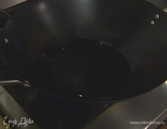 Вытереть вок бумажным полотенцем, влить 70–100 мл растительного масла.