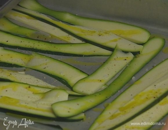 Два цукини разрезать вдоль на тонкие полоски, выложить на противень, немного сбрызнуть оливковым маслом, посолить и поперчить. Запекать в разогретой духовке 10–12 минут.