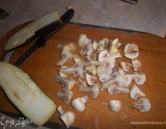 Баклажан помыть, разрезать вдоль на 2 части. Место разреза натереть солью и перцем, выпекать в разогретой духовке 20 мин при 180С. Шампиньоны разрезать на 4 части, и поджаривать на разогретом масле до готовности. 