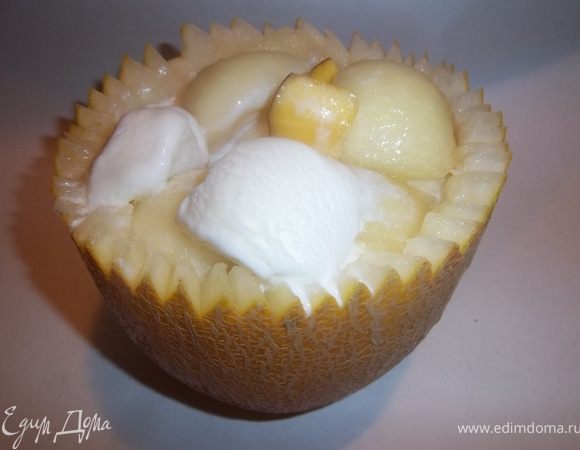 Вычистить семечки обыкновенной ложкой. Специальной ложкой для мороженого выскоблить мякоть равномерно по всей внутренней поверхности дыни, одновременно делая дольки-шарики. При помощи той же ложки сделать шарики из мороженого. В две получившиеся вазочки выложи десерт: дыню, мороженое  и нарезанные персики. Перед подачей поставь десерт на 30 минут в холодильник.
