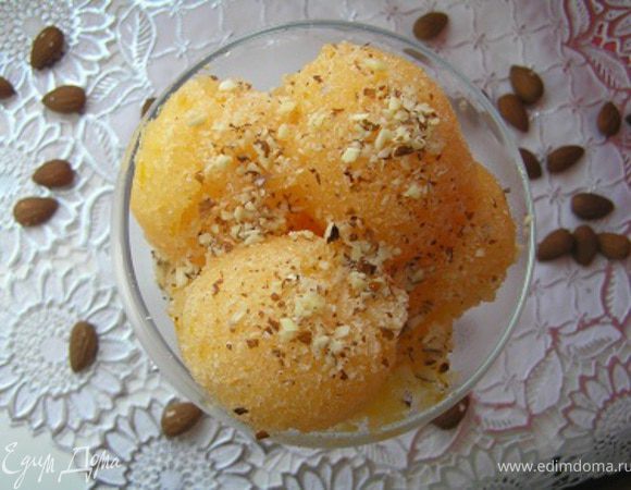 За 20-30 минут до подачи вынуть из морозилки, с помощью ложки сделать шарики, посыпать измельченным миндалем.